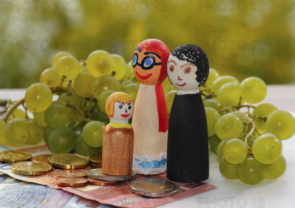 Wooden cone family with grapes and coins and banknotes, North Rhine-Westphalia, Germany