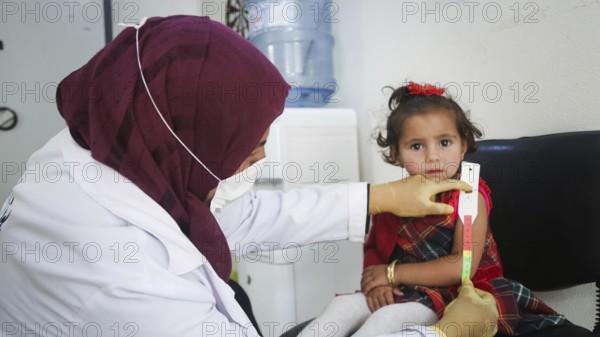 A doctor examines children's malnutrition inside a refugee camp. Malnutrition was measured using a mid-upper arm circumference belt. Aleppo, Syria October 29, 2022, Aleppo, Syria
