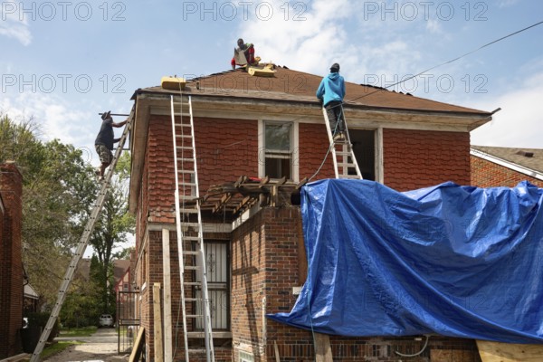 Detroit, Michigan - Workers re-roof a house they are remodeling in the Morningside neighborhood that had been vacant for many years. Detroit lost nearly two-thirds of its residents from 1950 to 2020 but has been growing modestly in recent years