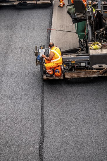 Rehabilitation of the A52 motorway near Essen, an 8 km long section between the Essen-Kettwig junction and the Essen-Ost motorway junction was completely renovated over a period of 9 years, 6 lanes, new drainage pipes, carriageway, bridges, noise barriers, traffic facilities, here the last section, direction Düsseldorf, new carriageway surface, laying of porous asphalt, asphalt paver applies the whispering asphalt, at the Essen-Rüttenscheid junction, North Rhine-Westphalia, Germany