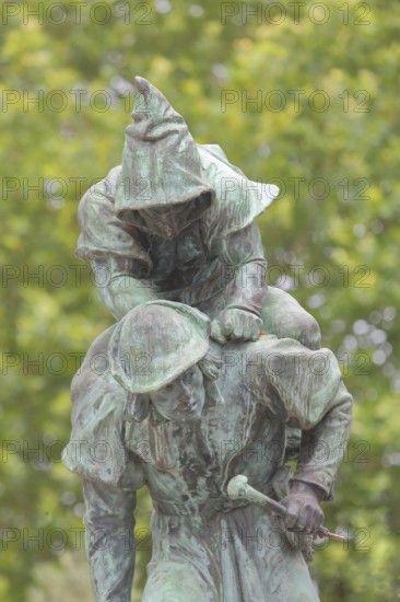 Sculpture Huckup monument by Carl Röder 1905, carrying figures on the back, modern art, bronze sculpture, loaded, transport, piggyback, carrying, shoulder, back, pointed cap, city history, legend, Hildesheim, Lower Saxony, Germany