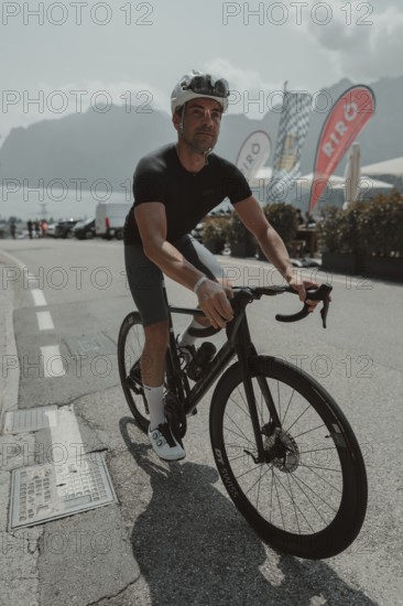 Young man riding a racing bike on Lake Garda. Sunny weather and dolce vita