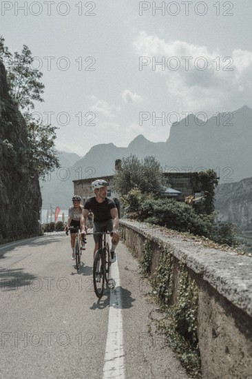 Woman and man cycling on Lake Garda in Italy. Sunny weather and dolce vita