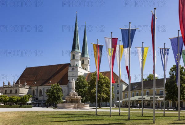 National flags at Kapellplatz with the collegiate parish church of St Philip and St James, place of pilgrimage, Altötting, Upper Bavaria, Bavaria, Germany