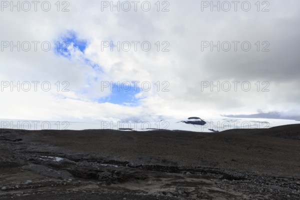 Black volcanic landscape with remnants of snow, Langjökull glacier, Husafell, Iceland