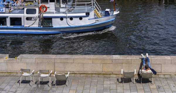 Promenade with chairs on the banks of the Spree from the Humboldt Forum, Berlin, Germany