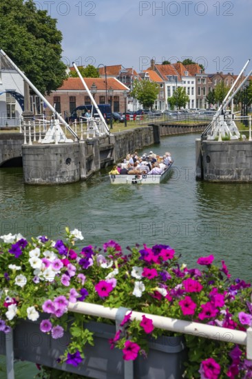 Middelburg, Zeeland, Netherlands - Town houses on the inner harbour in the old town. Tourists take a boat across the canals through the old town centre during a city tour