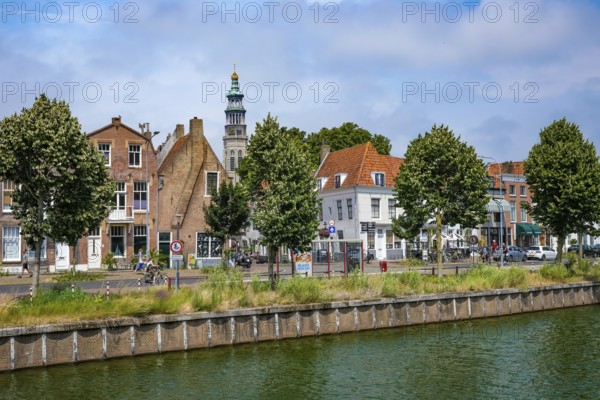 Middelburg, Zeeland, Netherlands - Townhouses on the Turfkaai at the Binnenhaven in the historic city centre. At the back is the Tall John Abbey Tower, a restored church tower from the 14th century with 207 stone steps leading to a viewing gallery