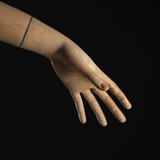 A detailed view of a mannequin hand with fingers slightly curled, creating a graceful pose against a dark background, showcasing the artistry in design and craftsmanship