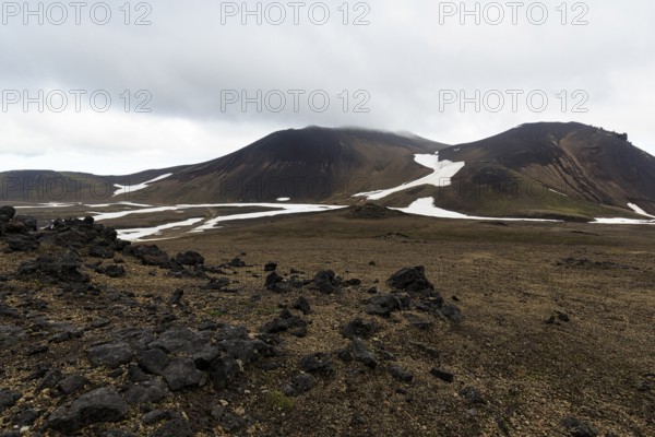 Barren volcanic landscape with snow fields, volcanic rock, mountain peaks with rain clouds, Snaefellsjökull, Snæfellsnes peninsula, Snaefellsnes, West Iceland, Iceland