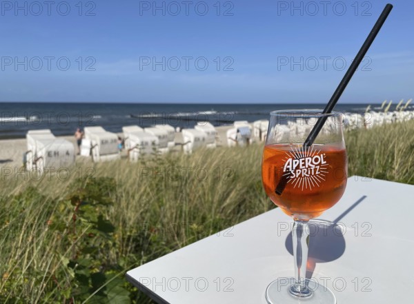 Glass of Aperol Spritz on a table overlooking the beach, Baltic resort Kühlungsborn, Mecklenburg-Vorpommern, Germany