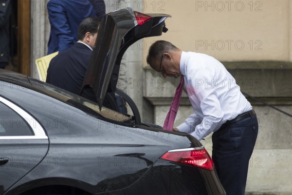 Friedrich Merz (CDU, German Chancellor) takes something out of a car boot in front of the joint meeting with Emmanuel Macron (President of the French Republic) at Villa Borsig in Berlin on 23 July 2025