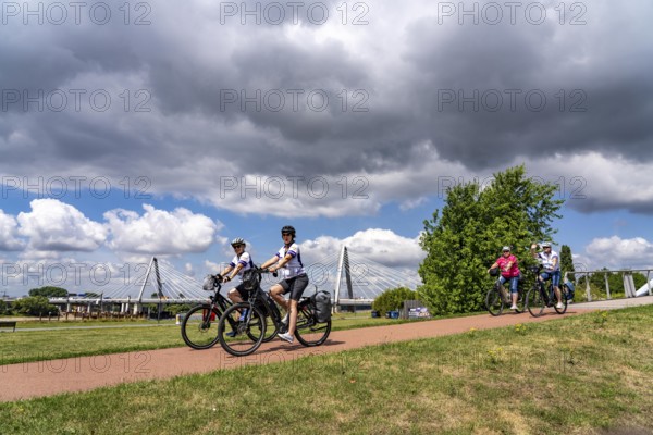 Cycle path in the Neulandpark in Leverkusen on the Rhine, in the background the new Rhine bridge of the A1, 1 construction phase, near Leverkusen, participants of the North Rhine-Westphalia Cycle Tour, 4-day, 220 KM long round trip through the Rhineland, with over 1400 participants, North Rhine-Westphalia, Germany