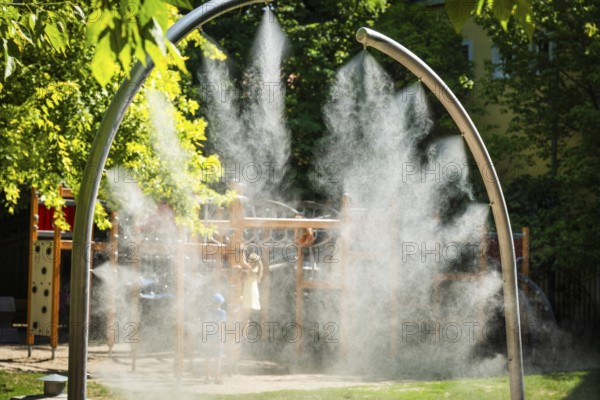 A mobile spray arch sprays fine water mist in a park in Bratislava, Slovakia