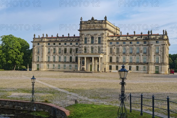 Ludwigslust Palace, built in the Baroque period and characterised by Classicism, with the palace square. In the foreground is the basin, a water basin with cascades and stone figures. Ludwigslust, Mecklenburg-Western Pomerania, Germany