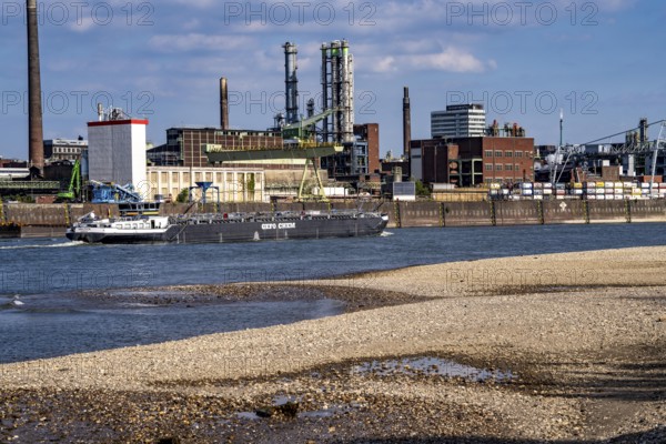 Low water of the Rhine near Leverkusen, Rhine bank, left bank of the Rhine, near Cologne-Merkenich, opposite Chempark Leverkusen, cargo ship on the Rhine, extremely low water level, no restrictions on inland navigation yet, North Rhine-Westphalia, Germany