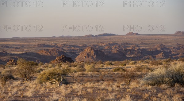 Desert landscape in the evening light at sunset, barren landscape with hills of stacked rocks, Erongo, Damaraland, Namibia