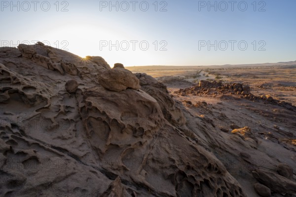 Eroded rock formations at sunrise with sun star, Erongo, Damaraland, Namibia