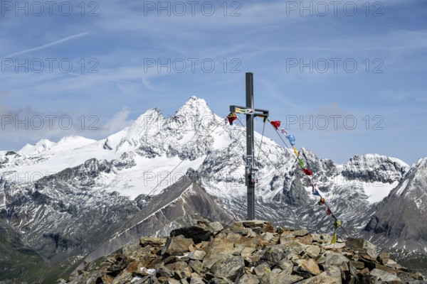 Summit cross of the summit Böses Weibl, behind summit of the Großglockner with snow, Schober group, Hohe Tauern National Park, Carinthia, Austria