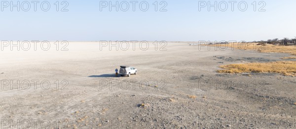 Dry salt pan, off-road vehicle on the salt pan, aerial view, Kubu Island, Botswana
