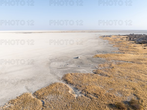 Rocky island with baobab trees in a dry salt pan, off-road vehicle on the salt pan, aerial view, Kubu Island, Sowa Pan, Makgadikgadi salt pans, Botswana