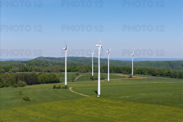 Row of wind generators on an undulating landscape with clear sky, Swabian Alb, Baden-Württemberg, Germany