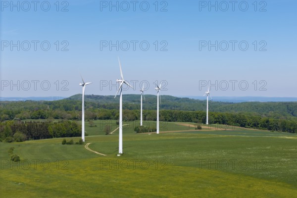 Several wind turbines on extensive meadows with forest in the background, Swabian Alb, Baden-Württemberg, Germany
