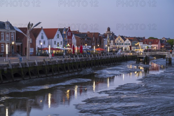 Buildings at the harbour, skyline, low tide, illuminated, blue hour, Husum, North Sea, North Frisia, Schleswig-Holstein, Germany