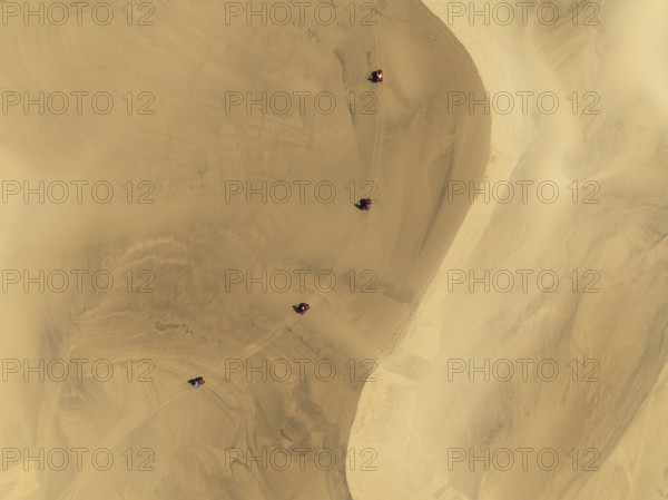 Quad bikes in the dunes of the Namib Desert in the vicinity of the coastal town of Swakopmund. Aerial view. Drone shot. Namibia