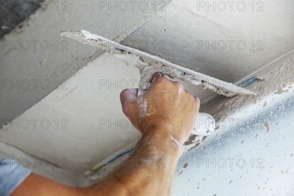 Plasterer smoothing and levelling interior walls