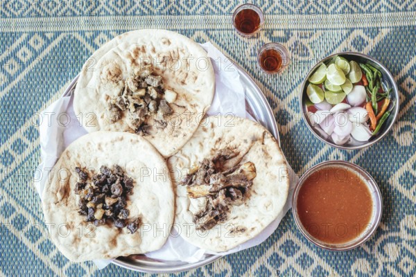 Traditional camel restaurant in Salalah, three kinds of camel meat (dry braised, boiled and grilled/baked), traditionally served with bread and chutney, Dhofar, Oman