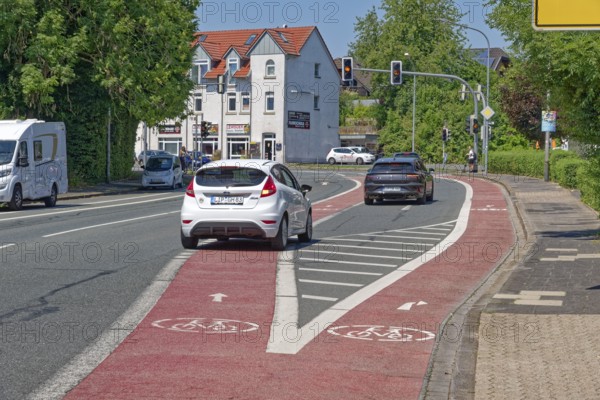 Divided cycle lanes for cyclists going straight ahead and turning right in front of a traffic light on Herforder Strasse. The right-turn lane for motorists is in between. City centre of Lemgo, North Rhine-Westphalia, Germany
