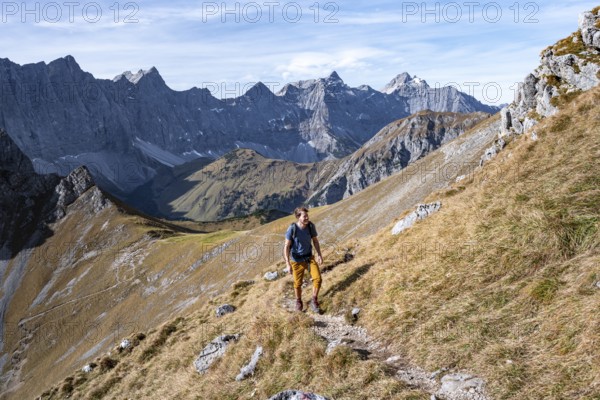 Mountaineers on a hiking trail at the Gamsjoch, picturesque mountain landscape in autumn, view of the rocky mountain ridge of the Hinterautal-Vomper chain, Rißtal in the Eng, Karwendel, Tyrol, Austria