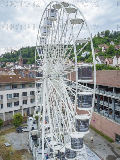 A large Ferris wheel in an urban environment with a cloudy sky, Ferris wheel construction for the 950th anniversary of the city of Calw, Black Forest, Germany
