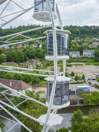 View from a Ferris wheel onto a cityscape with lots of greenery and houses, Ferris wheel construction for the 950th anniversary of the town of Calw, Black Forest, Germany