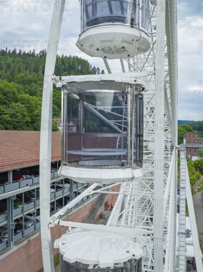 Three gondolas of a Ferris wheel, surrounded by green landscape and sky, Ferris wheel construction for the 950th anniversary of the town of Calw, Black Forest, Germany