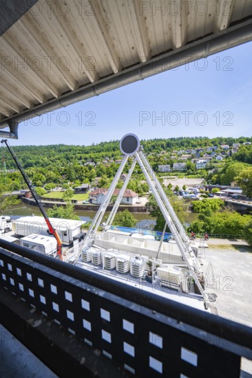 A Ferris wheel seen from above, surrounded by green landscape and buildings, Ferris wheel construction for the 950th anniversary of the town of Calw, Black Forest, Germany