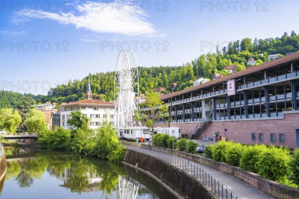 Ferris wheel is located in a cityscape next to a river, Ferris wheel construction for the 950th anniversary of the city of Calw, Black Forest, Germany