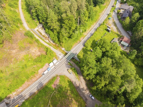 A railway bridge leads over a road, surrounded by forest and vehicles, construction of the Hermann Hessebahn, Calw, Germany