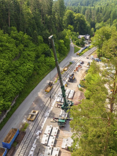 Construction site along railway tracks in a dense forest, crane in action, construction of the Hermann Hesse railway, Calw, Germany