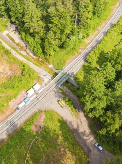 A railway crossing in the middle of a forest with several roads and vehicles, construction of the Hermann Hessebahn, Calw, Germany
