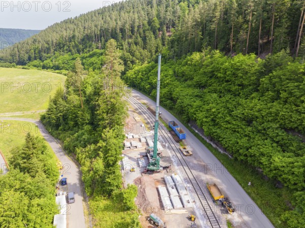 Construction work along a railway line in a green forest area, crane and concrete blocks visible, construction of the Hermann Hesse railway, Calw, Germany