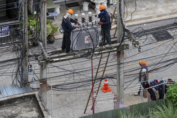 Electricians working on power lines, Pattaya, Thailand