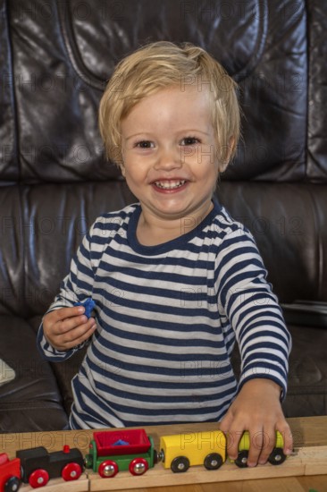 Blond boy, 2 years old, playing with toy train in Ystad, Skåne County, Sweden, Scandinavia