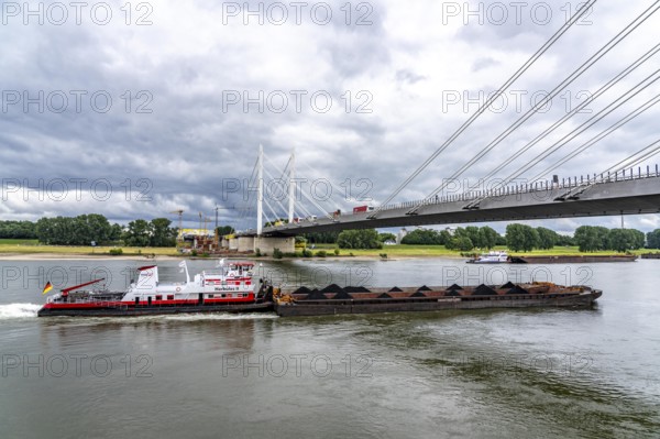 Rhine bridge Duisburg-Neuenkamp, the A40 motorway, start of construction of the second bridge, bridge piers and the first bridge segment are erected on the Neuenkamp side of the Rhine, cargo ship on the Rhine, push boat Herkules II, push convoy, with coal for the HKM coking plant in Duisburg, North Rhine-Westphalia, Germany