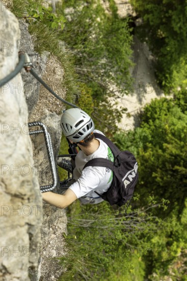 Mountaineer climbing over a steep ladder in the Isidor via ferrata, Grünstein, Schönau am Königssee, Berchtesgadener Land, Upper Bavaria, Bavaria, Germany