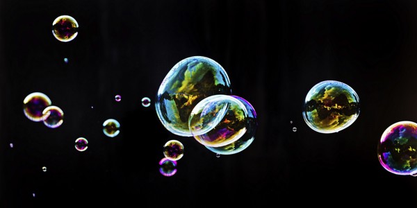 Iridescent soap bubbles in the colours of the rainbow against a black background, Recklinghausen, North Rhine-Westphalia, Germany