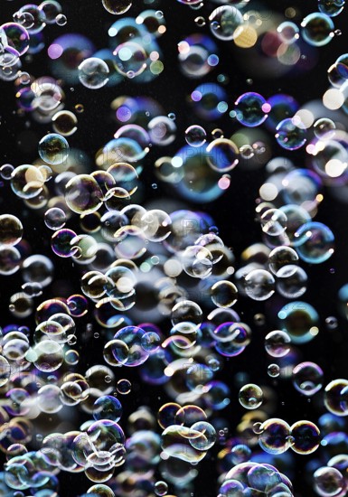Many, small iridescent and floating soap bubbles against a black background, Recklinghausen, North Rhine-Westphalia, Germany