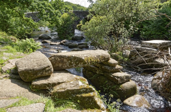 Remains of an old stone bridge and the new bridge on the East Dart River in Dartmoor National Park. Dartmeet, Devon, South England, Great Britain
