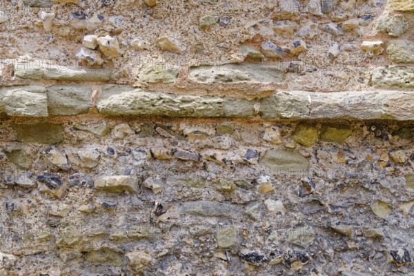 Masonry of the historic castle wall of Pevensey Castle, a Norman castle, in the village of Pevensey, Sussex, England, Great Britain